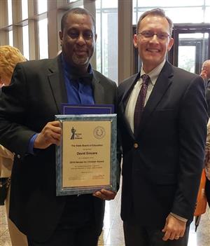 Cropped photo of Sincere holding 2018 Heroes for Children award with Indelicato 